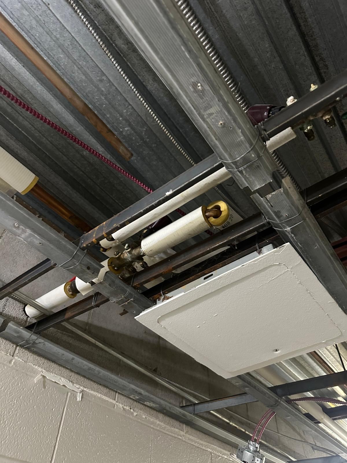 Insulated overhead piping above ceiling access panel